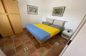 a bedroom with a bed with a yellow and blue blanket at Villetta Greco - Torre Lapillo in Porto Cesareo