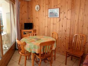jadalnia ze stołem, krzesłami i telewizorem w obiekcie Studio lumineux au centre de Flaine avec balcon et kitchenette - FR-1-425-152 w mieście Flaine