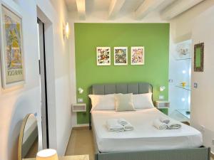 シラクーサにあるCasuzzaの緑の壁にベッドが備わる小さなベッドルーム1室
