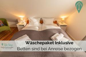 een slaapkamer met een bed met 2 lampen en handdoeken bij Haus Hamburg OG in Greetsiel