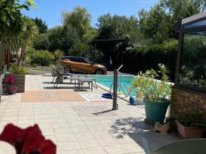 eine Terrasse mit Tisch und Swimmingpool in der Unterkunft Maison familiale avec piscine chauffée, proche plages et La Baule - FR-1-306-1266 in Saint-Molf