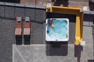 una mujer está en una piscina en un edificio en With jacuzzi sea view - Casa da Quinta Grande, en Câmara de Lobos