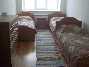 a bedroom with two beds and a rug on the floor at Hostel Pomor in Barentsburg