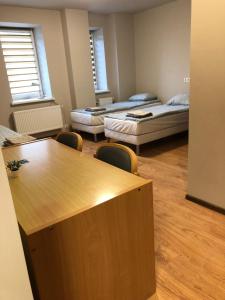 a room with two beds and a table and chairs at RVR Smart Apartments Riga with Self Check-In in Rīga