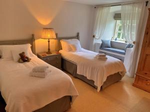 a bedroom with two beds and a teddy bear on the bed at Finest Retreats - Ingleby Manor - South Front in Great Ayton