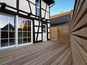 une terrasse en bois avec des fenêtres et un bâtiment dans l'établissement Maison Geispolsheim, 5 pièces, 8 personnes - FR-1-722-5, à Geispolsheim