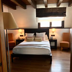 a bedroom with a bed and two orange chairs at LA HOSTERIA DE TOLORIU, el alt Urgell in Toloríu