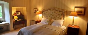 a bedroom with a bed with two lamps and twoitures at Finest Retreats - Ingleby Manor - Gun Room in Great Ayton