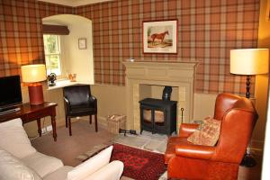 a living room with a couch and a fireplace at Finest Retreats - Ingleby Manor - Gun Room in Great Ayton