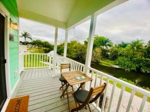 a porch with a table and chairs and a river at Pinecraft Tiny Home 'Green Parrot ' in Sarasota