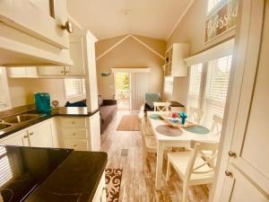 uma cozinha com mesa e cadeiras e uma sala de jantar em Pinecraft Tiny Home 'Green Parrot ' em Sarasota