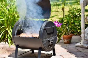 una parrilla con humo saliendo de ella en un patio en Pinecraft Tiny Home 'Green Parrot ', en Sarasota