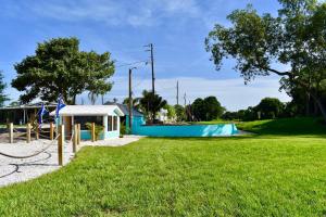 a park with a blue building and a playground at Pinecraft Tiny Home 'Green Parrot ' in Sarasota