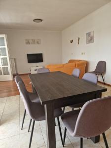 a dining room with a wooden table and chairs at Apartment Marta in Rab