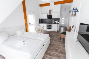 um quarto branco com uma cama e uma cozinha em Hotel Apartments Restaurant CALA LUNA em Marburg an der Lahn