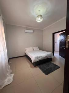 a bedroom with a bed in a white room at Bantuz House in Livingstone