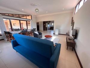 un sofá azul en una sala de estar con bar en Bantuz House en Livingstone