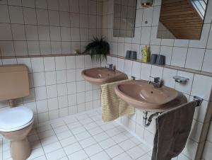 a bathroom with two sinks and a toilet at Ferienwohnung Pusteblume in Marktbergel