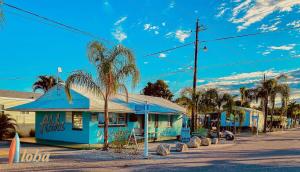 a street with a blue building and palm trees at Pinecraft Tiny Home 2 in Sarasota