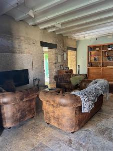 sala de estar con muebles de cuero y sofá grande en LA HOSTERIA DE TOLORIU, el alt Urgell en Toloríu