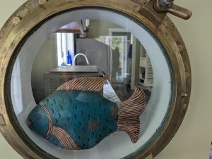 a mirror with a picture of a fish in it at Captains Quarters by the Beach in Ellsworth