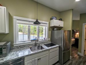 a kitchen with a sink and a stainless steel refrigerator at Captains Quarters by the Beach in Ellsworth