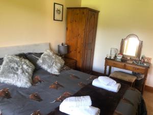 a bedroom with a bed with leaves on it at The Woolly Rock in North Ballachulish