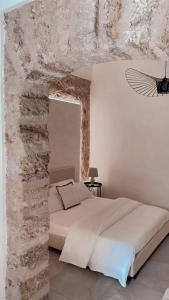 um quarto com uma cama com uma parede de pedra em Loft Zisa em Palermo