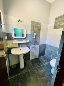 班德勒韋勒的住宿－St. Judes Holiday Resort，一间带水槽、淋浴和卫生间的浴室