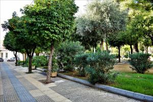 ein Park mit Bäumen und Pflanzen auf dem Bürgersteig in der Unterkunft Egaleo Relax Apartment in Athen