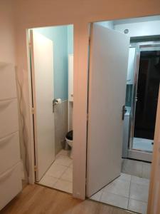 een open deur naar een badkamer met een toilet bij Appt RdC terrasse, 300m plage. in Courseulles-sur-Mer