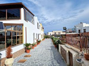 een loopbrug met potplanten aan de zijkant van een gebouw bij Rosa's house in Lipari