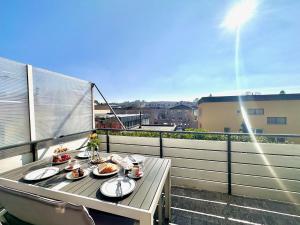 a table with plates of food on a balcony at 80qm Luxus Apartment mit großer Terrasse in Saarbrücken