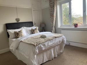 een slaapkamer met een groot wit bed en een raam bij ABI B&B in Kent