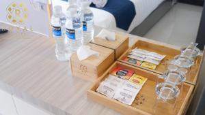 a table with bottles of water and glasses on it at Royal Suites Studio 28th Floor - Citra Plaza Nagoya Apartment in Jodoh