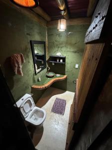 a bathroom with a toilet and a sink and a mirror at Pousada Reserva Setiba Guarapari in Guarapari