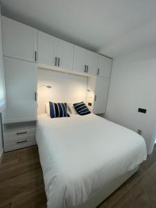 a bedroom with a large white bed and white cabinets at Rancho Luxury apartments in Platja d'Aro