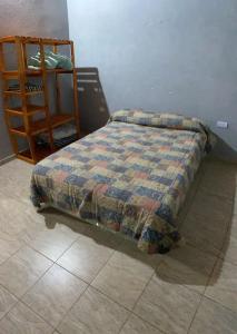 a bed with a quilt on the floor in a bedroom at Luz maria in Empedrado