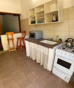 a kitchen with a counter with a sink and a stove at Luz maria in Empedrado