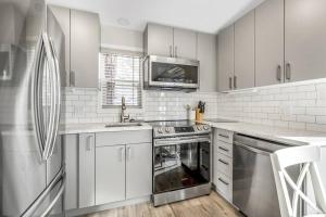a white kitchen with a sink and a dishwasher at Family-friendly Cottage with amazing views in West Kelowna