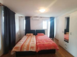 um quarto com uma cama com um edredão vermelho em Villa Meadow em Kobiljača