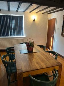 a wooden table with chairs and a basket on top at Antic Cottage for Family in Nottingham