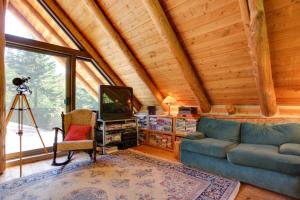 a living room with a couch and a tv in a cabin at Cozy Easton Cabin with Wenatchee Natl Forest Views! in Cabin Creek