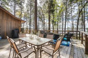 a table and chairs on a deck with trees at Secluded Avinger Home with Lake Access! in Avinger
