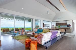 普羅維登西亞萊斯的住宿－Breathtaking Oceanfront Villa with Views and Private Pool，客厅配有沙发和桌子
