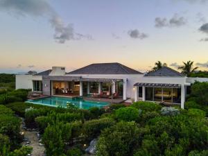 une grande maison avec une piscine dans la cour dans l'établissement Breathtaking Oceanfront Villa with Views and Private Pool, à Providenciales