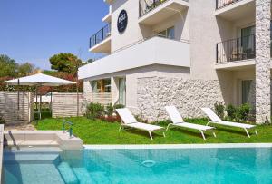 une maison avec deux chaises et une piscine dans l'établissement 1935 Hotel Boutique by Terraza, à Roses