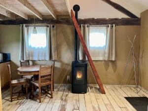 a wood stove in a room with a table at La Bushaye in Aubel