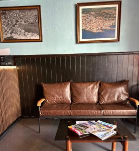 un sofá de cuero marrón en una habitación con mesa en New Roser en L'Escala