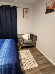 a living room with a couch and a chair at Cozy one bedroom in Airdrie in Airdrie